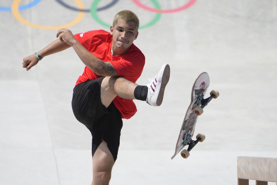 A skateboarder kicks his board.