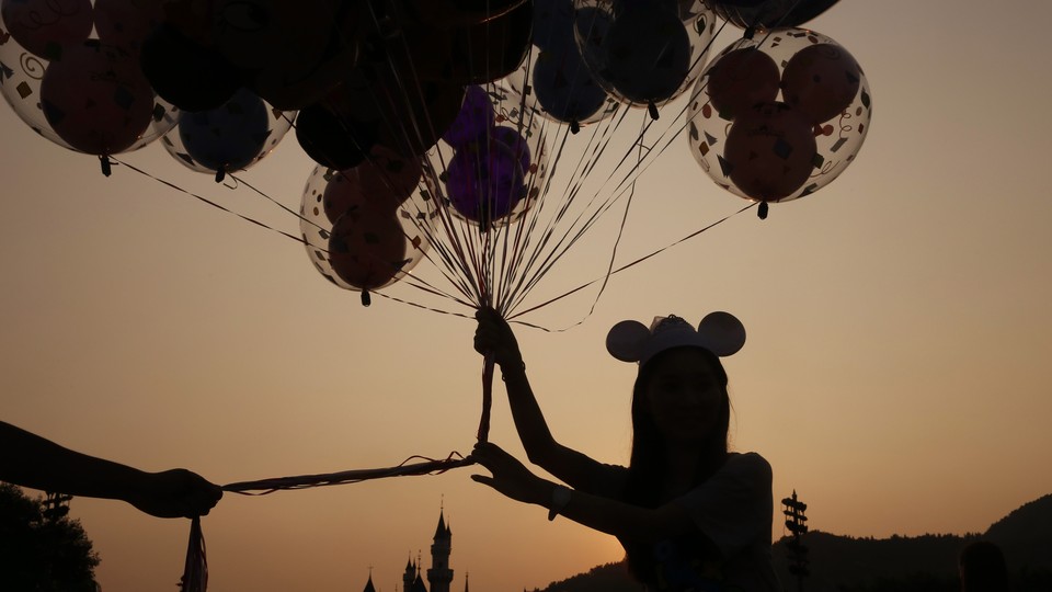 A woman holding balloons at the Hong Kong Disneyland