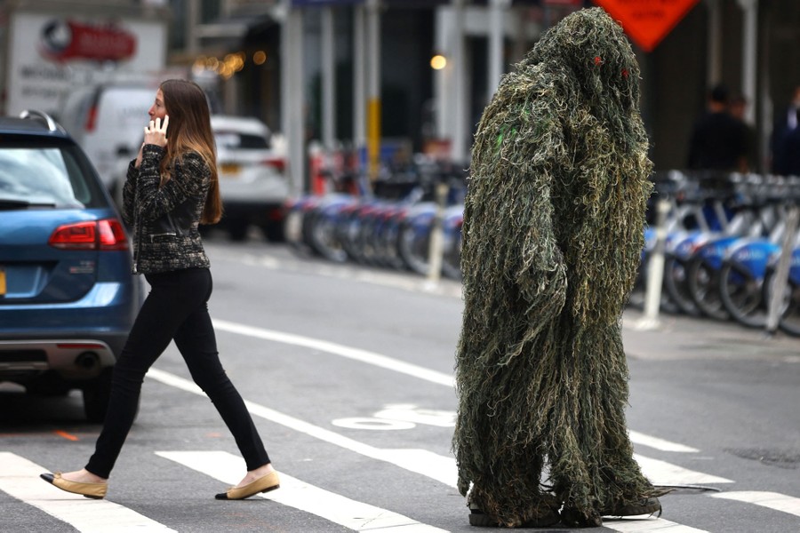 A man in a shaggy costume crosses a street in midtown Manhattan.