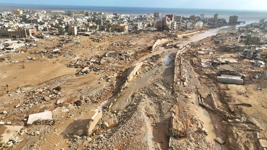 An elevated view of extensive flood damage along a river channel through a city