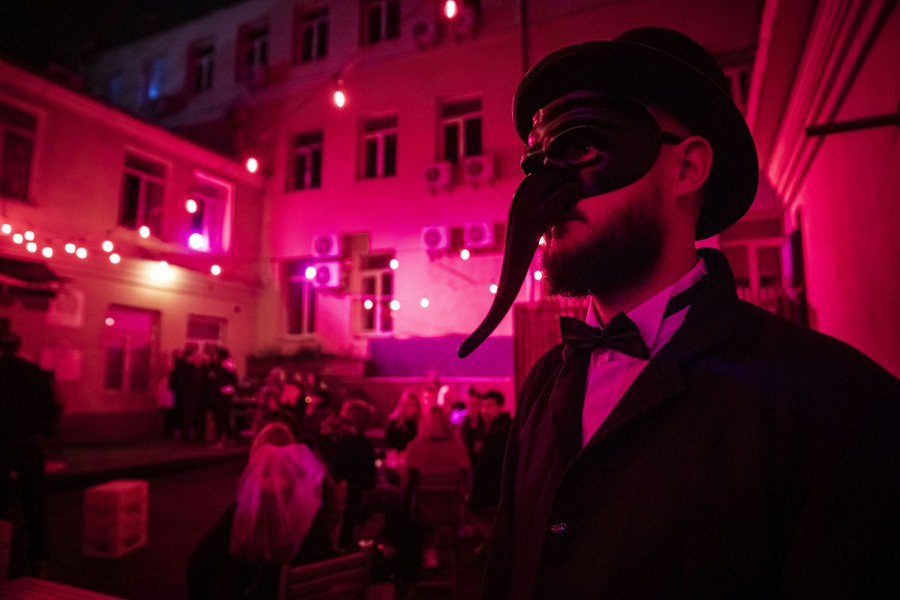 Masked attendees, photographed outside a club during a party