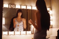 Cher looking in the mirror as a young person