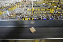 A cardboard box on a conveyor belt inside a warehouse