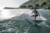 A surfer rides on a small wave.