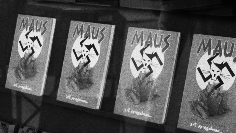 A black and white image of four 'Maus' books on a shelf. The cover depicts two mice huddled together under a swastika that bears the image of a cat drawn to look like Hitler