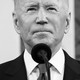Joe Biden in front of microphone in black and white