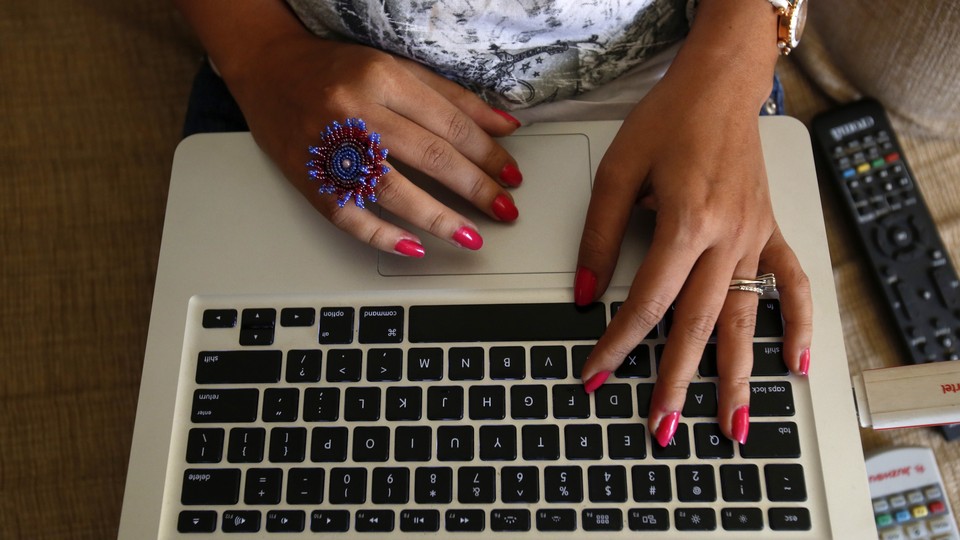 A person types on an Apple laptop keyboard