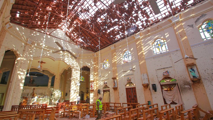 A crime-scene official inspects the site of a bomb blast inside a church in Negombo, Sri Lanka.