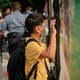 A student looks through a fence at a school.