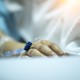 A hand rests on a hospital bed.