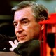 Fred Rogers resting near a trolley on a TV set