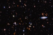 A field of thousands of small galaxies of various shapes and colors on the black background of space