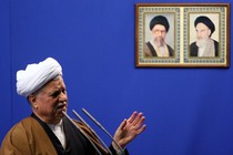 Former President Ali Akbar Hashemi Rafsanjani speaks under the pictures of Iranian late spritual leader Ayatollah Khomeini, right, and supreme leader, Ayatollah Ali Khamenei.