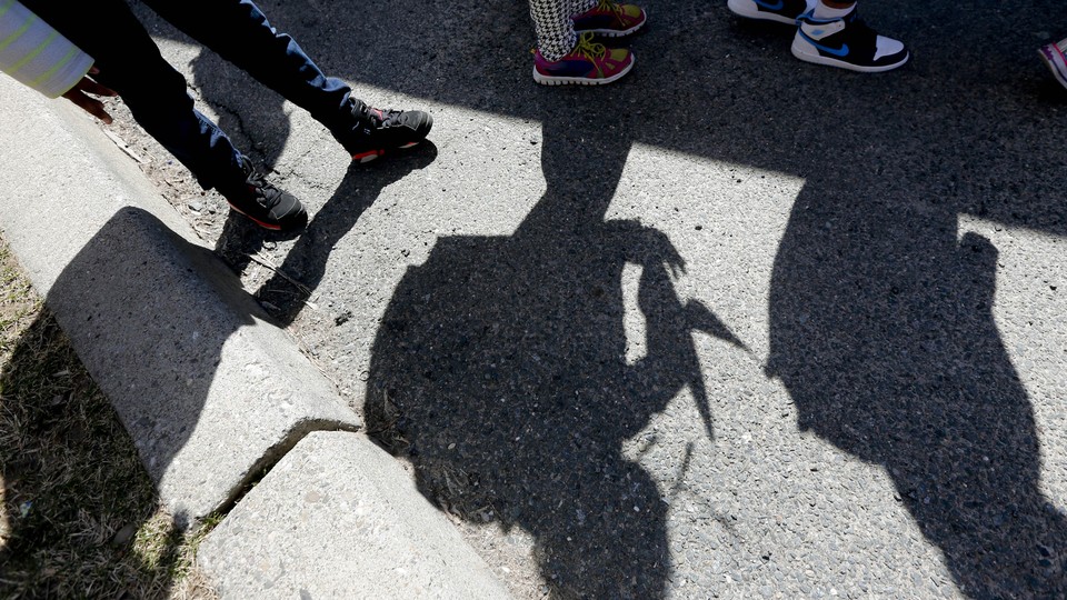 Shadows of students and their sneakers waiting for a school bus