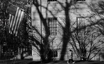Black-and-white photo of American flag hanging from college building