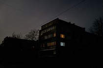 A building with a few lights on inside at dusk