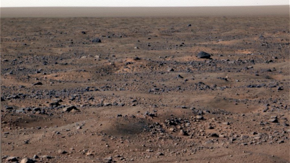 A rocky, dusty, pale brown and gray landscape with no signs of life