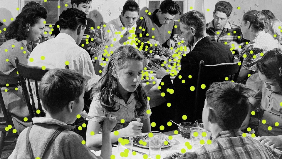 An illustration of people at a Thanksgiving table with droplets of the virus spreading from peoples' mouths.