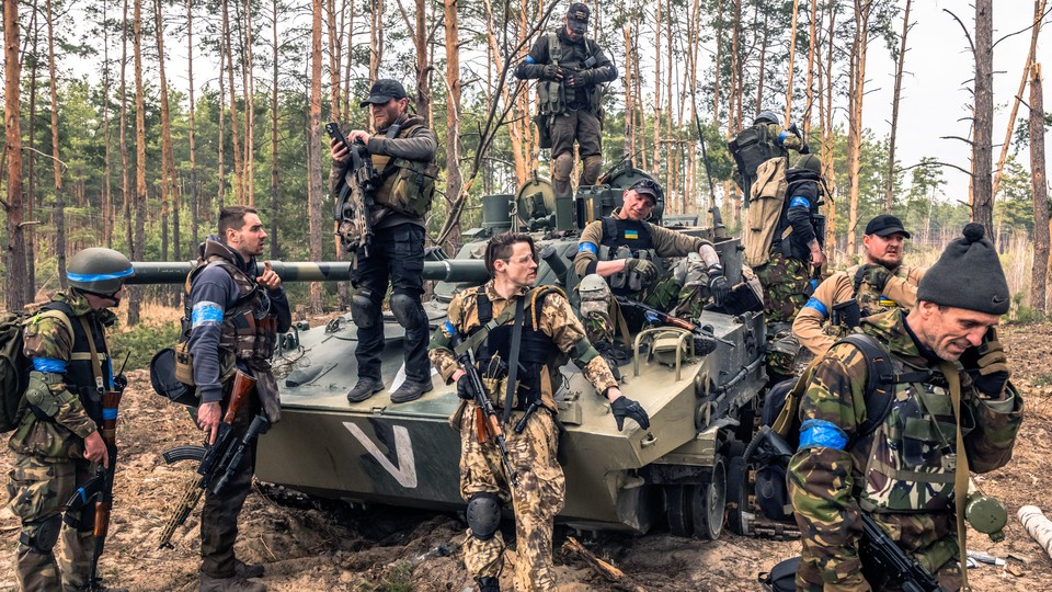 Ukrainian soldiers and foreign fighters gathered around a tank during a military operation