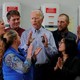 Joe Biden speaks surrounded by a circle of staff members and supporters.