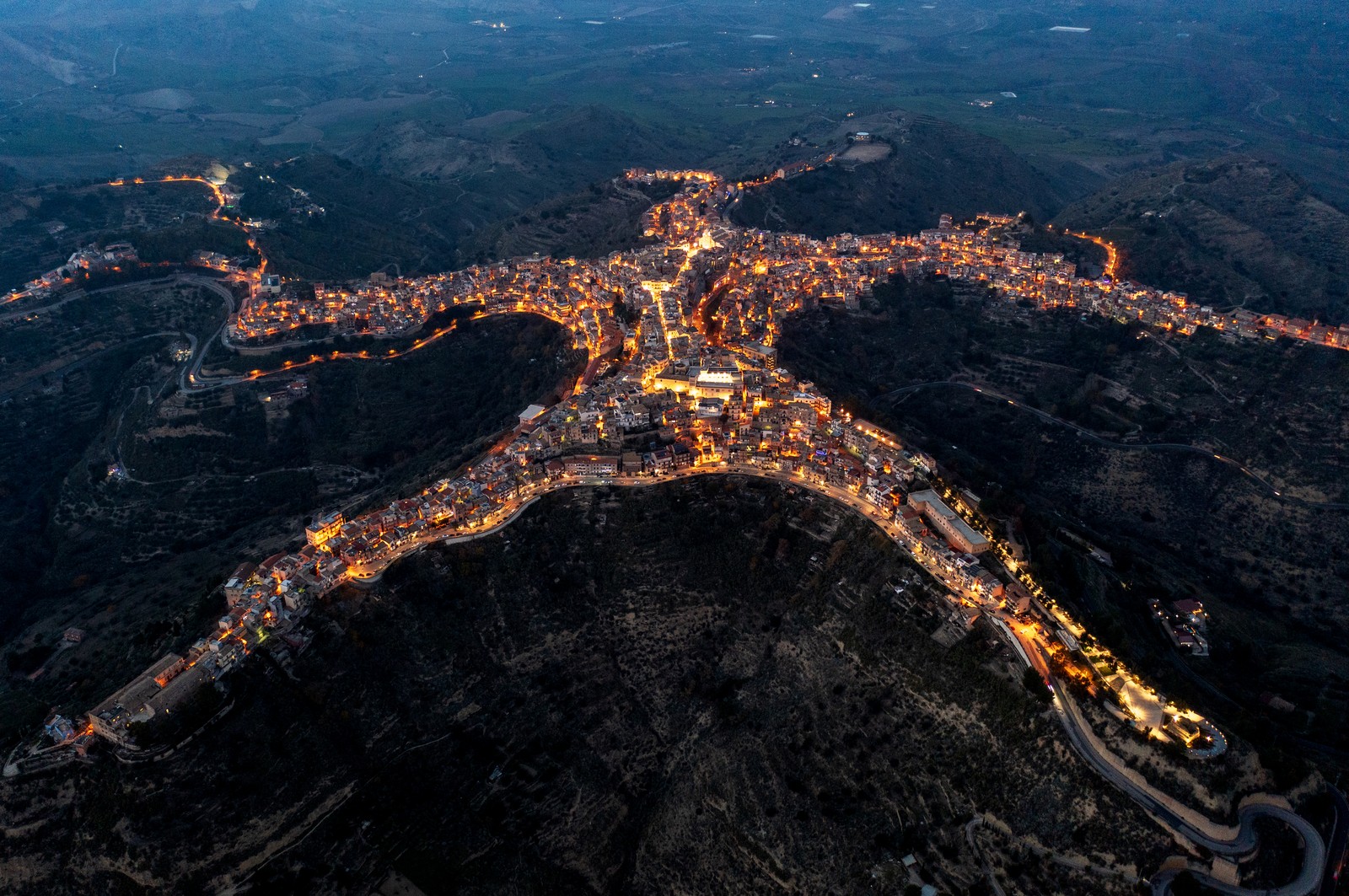 An aerial view of a hilltop town in Italy, vaguely shaped like a starfish.