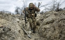 A photo of a Ukrainian soldier running through a trench