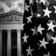 A photo showing an American flag in the foreground and the Supreme Court in the background