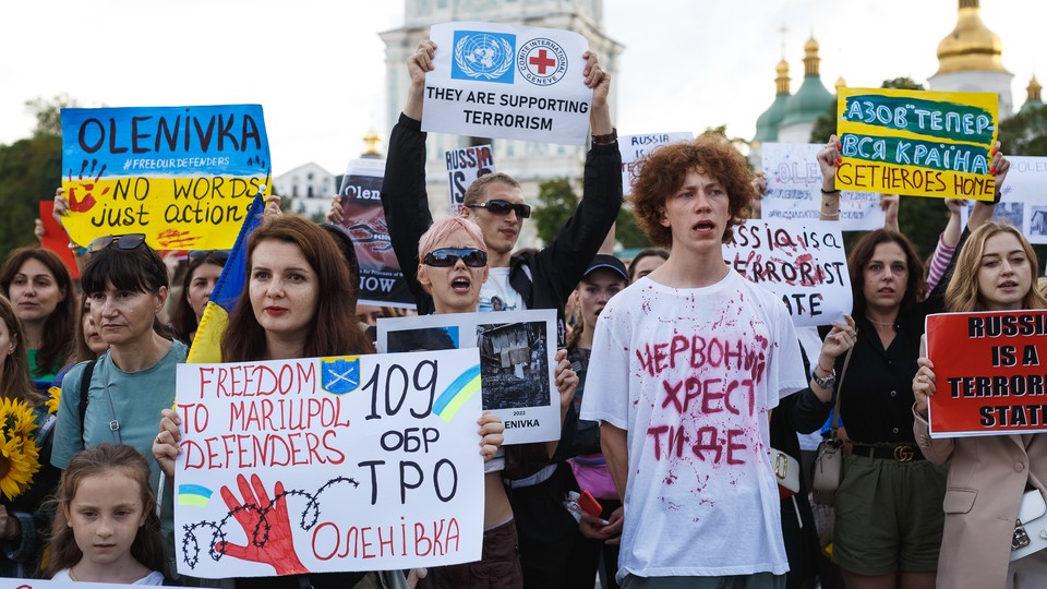 People hold banners during an August 4 protest in Kyiv, Ukraine.