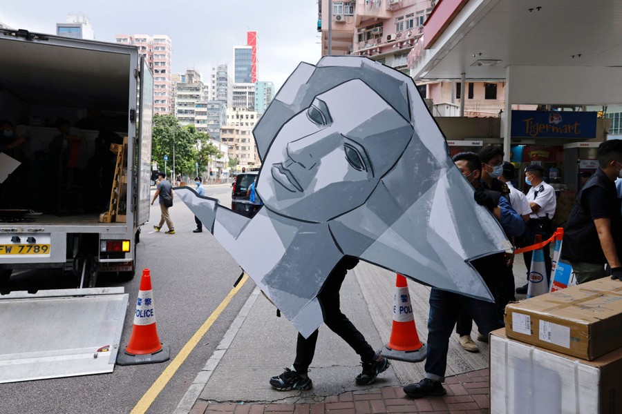 Hong Kong police remove a cutout of the Goddess of Democracy from a museum.