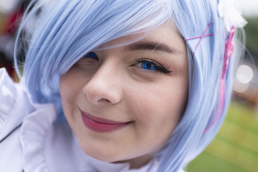 A person dressed up as an anime character, with light blue hair and blue-colored contacts