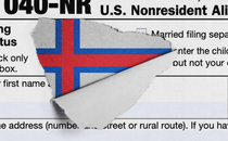 A tax form which is ripped to reveal the flag of the Faroe Islands.