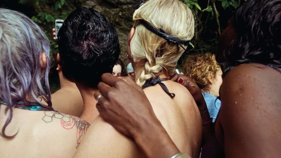 Four people photographed from behind, hugging each other