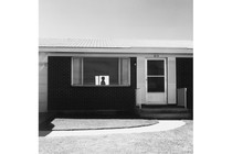 Silhouette of person visible through suburban house window