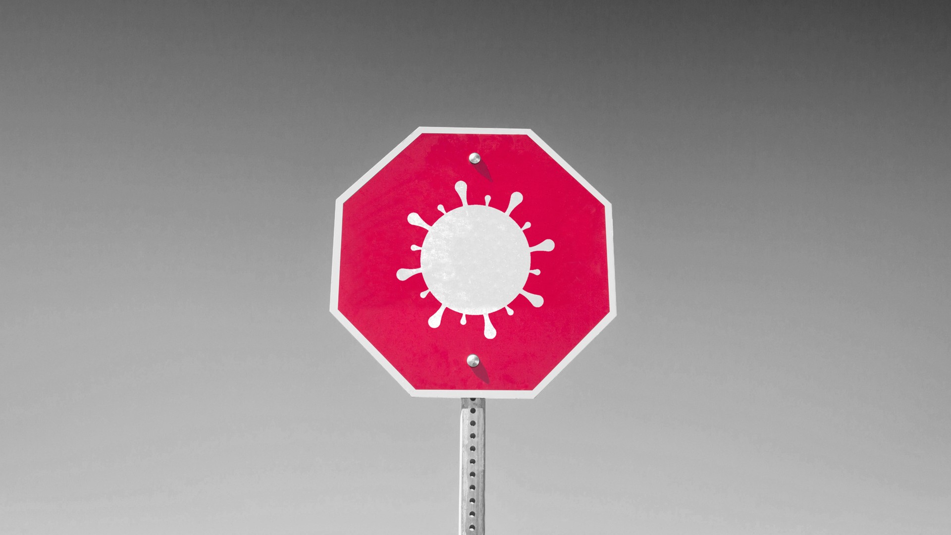 An image of a red stop sign with a Covid-19 "germ" symbol on top in white instead of the word "Stop."