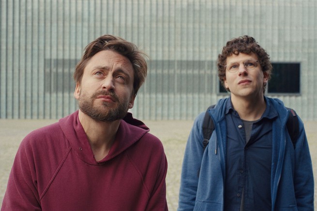 Two men looking up at something in the sky, one is Jesse Eisenberg