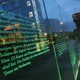 Articles of Germany's Basic Law (Grundgesetz), including article 5, which guarantees freedom of expression, the arts, and the press, stand illuminated on a glass wall in Berlin.