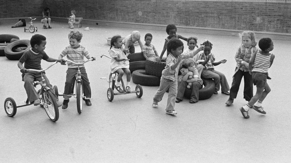 A black and white image of a group of children on a playground