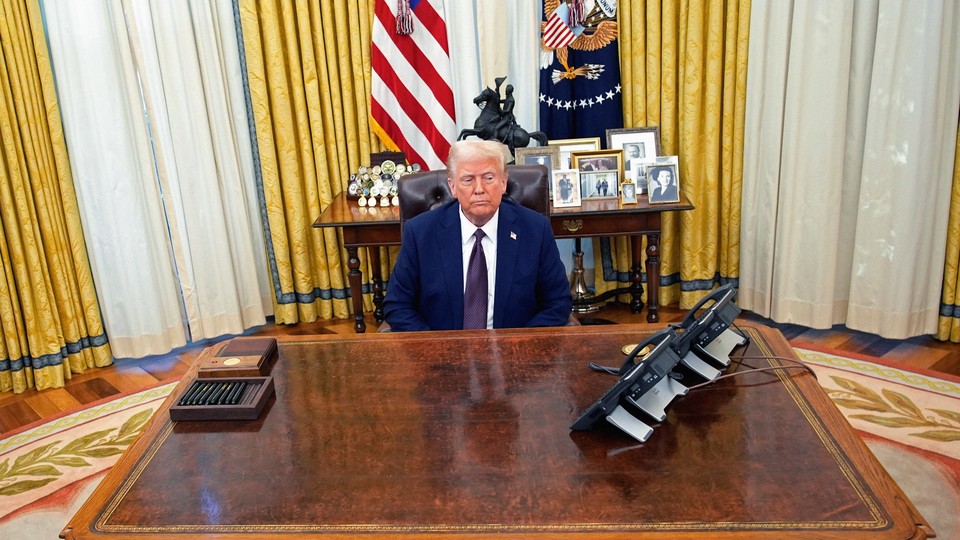 An image of Donald Trump sitting at the Resolute Desk.