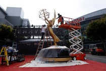 Workers install a large Emmy statue ahead of the 2017 awards ceremony