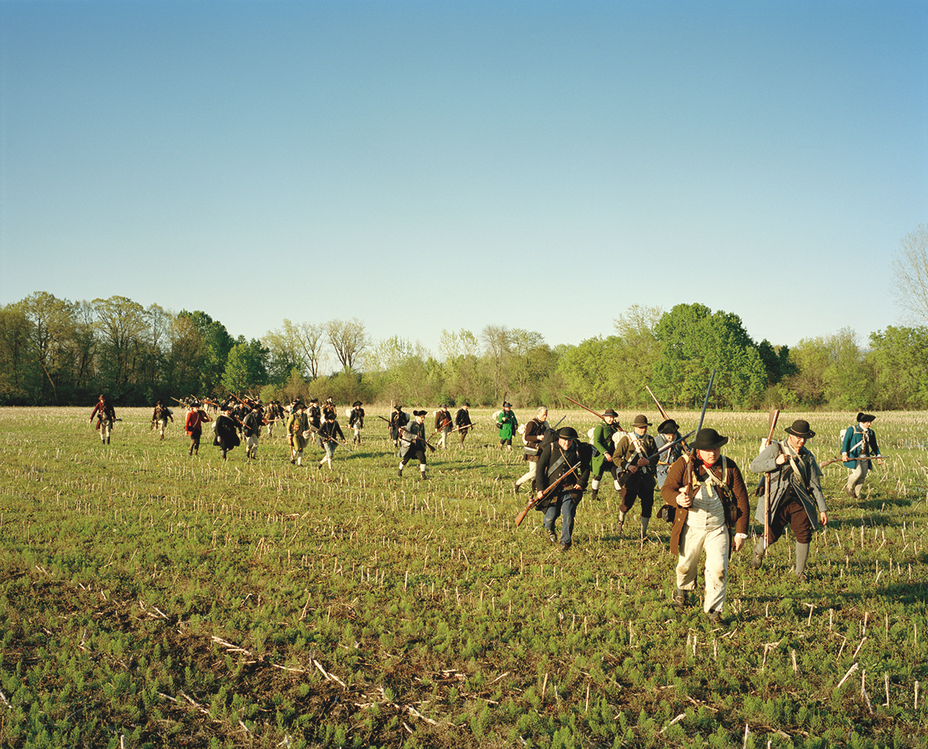 photo of reenactors as American soldiers hiking towards Fort Ticonderoga across an open field