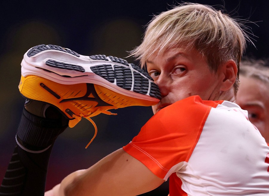 An athlete playing handball is struck in the nose by the foot of another player.
