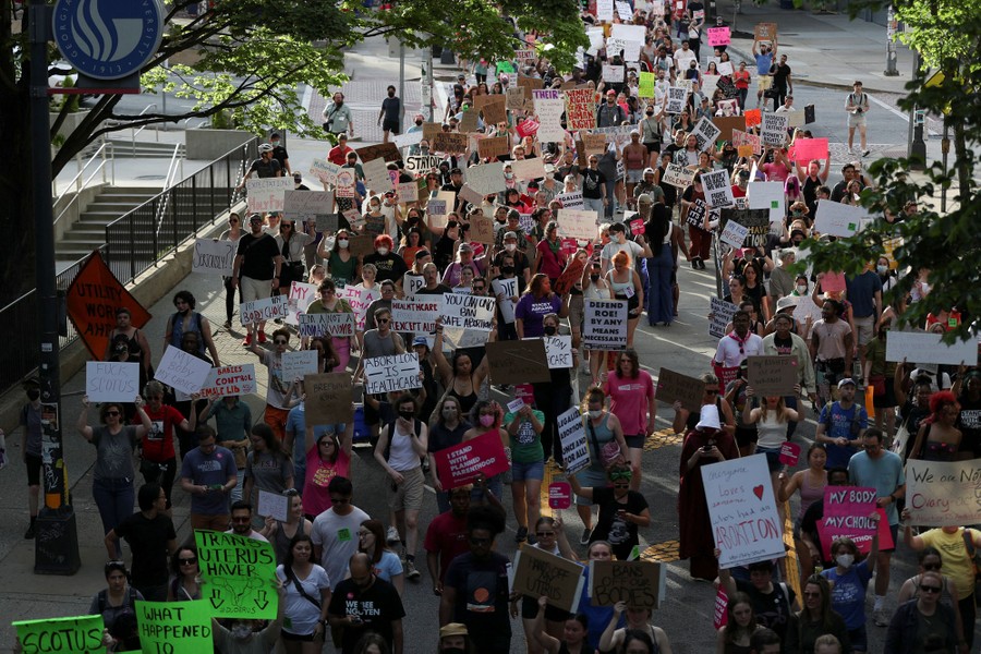 A long column of protesters marching along the street.