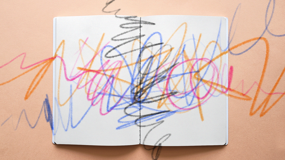 A coloring book covered in multicolor scribbles, as if from crayons