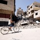 A boy rides on a bicycle in the town of Kafr Batna, in eastern Ghouta, Syria on September 5, 2018.