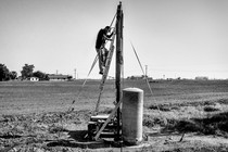 USA. Stratford, California. 2013. A man repairs his dry well.