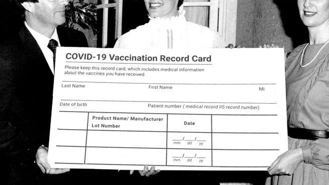 People holding giant vaccination card like a giant check