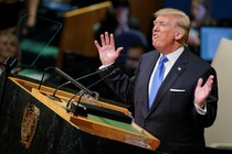 President Donald Trump is shown on a large screen. 