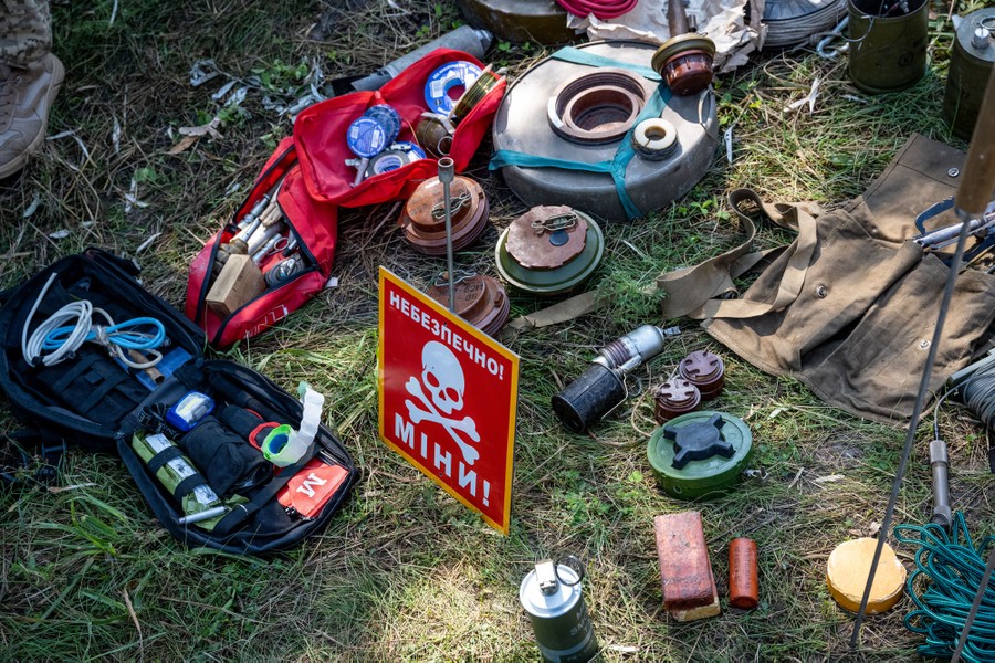 A loose pile of defused mines and other explosive devices sits on grass, during a class for soldiers.