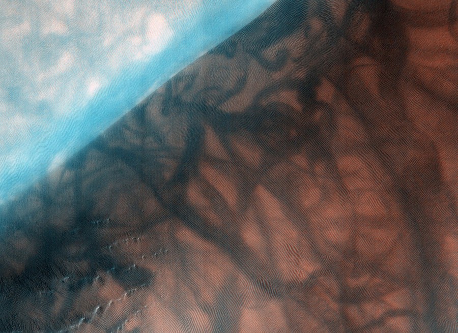 Swirling streaks cover the ridge of a dune.