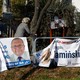 Women ride bicycles past election posters, a day after parliamentary election, in Raszyn